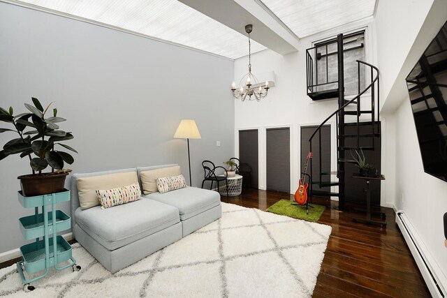 212 9th St Unit 4B, Jersey City, NJ 07302 - living room featuring a baseboard heating unit, wood-type flooring, a chandelier, and stairs