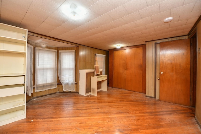 unfurnished living room featuring hardwood / wood-style flooring and wood walls