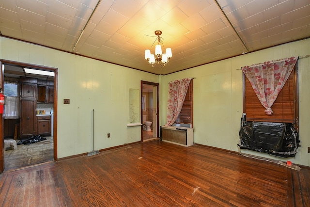 unfurnished living room with dark wood-type flooring and a chandelier