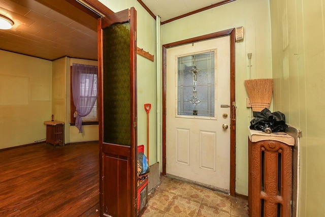 entryway with wood-type flooring and ornamental molding