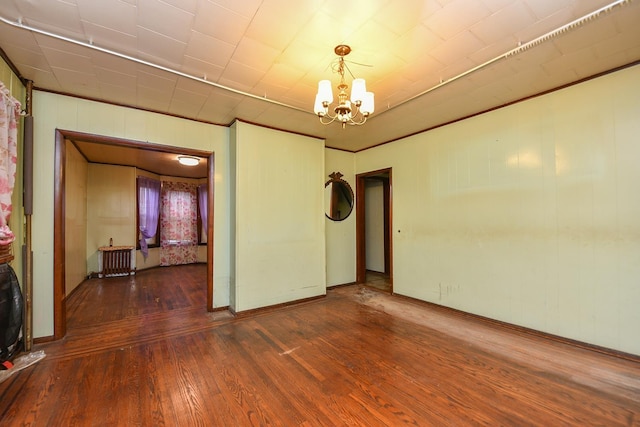 empty room featuring dark hardwood / wood-style floors and an inviting chandelier