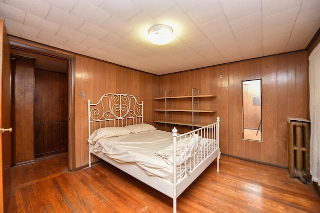 bedroom with wooden walls and dark hardwood / wood-style floors