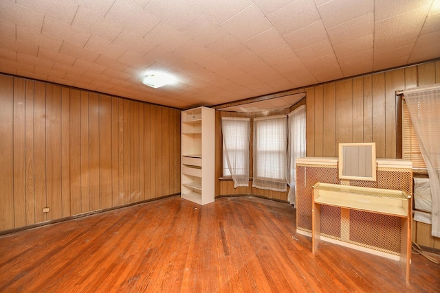 interior space featuring hardwood / wood-style floors and wooden walls