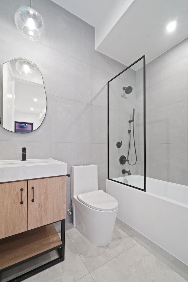 full bathroom with vanity, toilet, tiled shower / bath combo, and tile walls