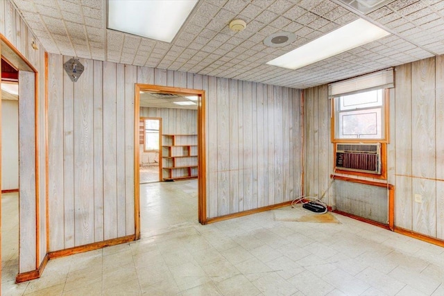 spare room with cooling unit and wooden walls