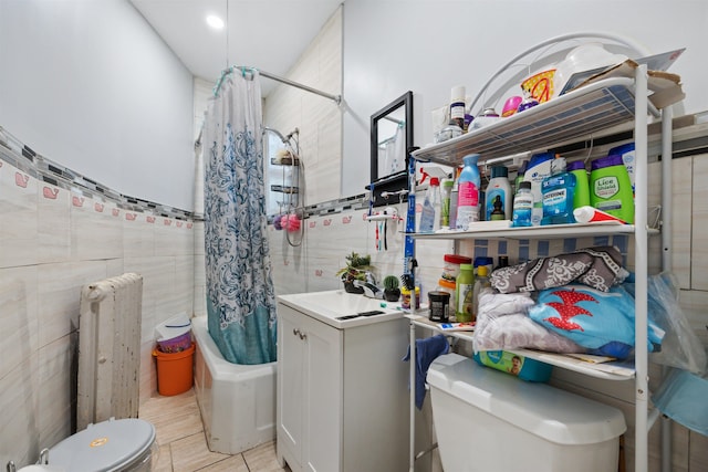 full bathroom featuring tile patterned flooring, tile walls, shower / bathtub combination with curtain, radiator, and sink