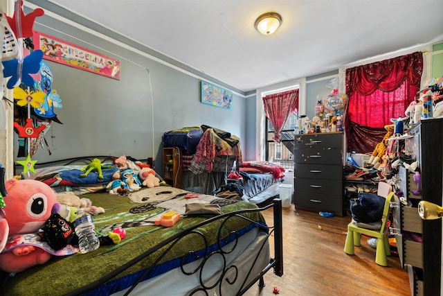 bedroom with crown molding and wood-type flooring