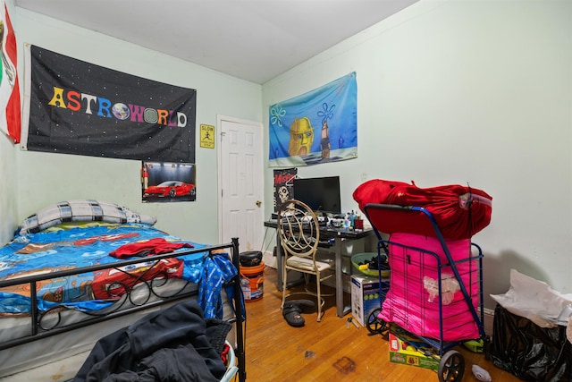 bedroom featuring ornamental molding and hardwood / wood-style floors