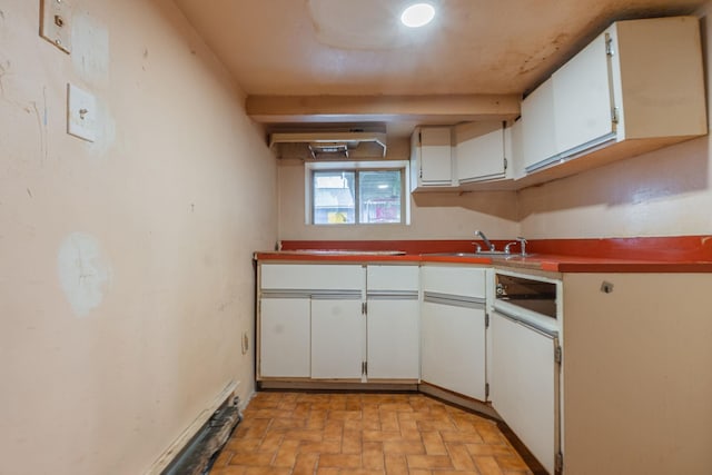 509 81st St, North Bergen, NJ 07047 - kitchen featuring a sink, white cabinets, and brick patterned floors