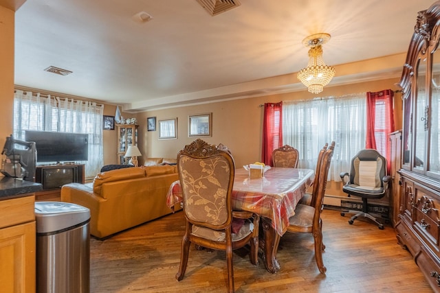 509 81st St, North Bergen, NJ 07047 - dining space featuring healthy amount of natural light, light wood finished floors, and a chandelier