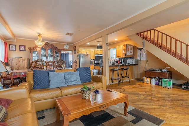 509 81st St, North Bergen, NJ 07047 - living area featuring a chandelier, light wood-style flooring, stairway, and crown molding