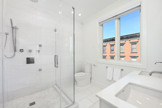 full bathroom featuring tile patterned floors, toilet, a sink, a shower stall, and baseboards