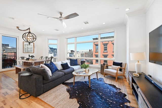 living area with recessed lighting, visible vents, ornamental molding, and light wood finished floors