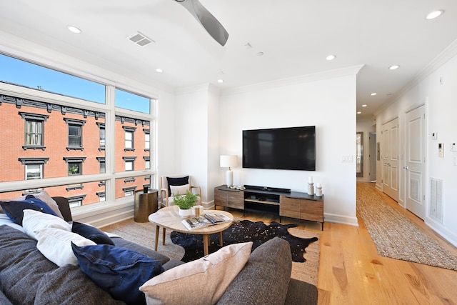 living area featuring recessed lighting, visible vents, wood finished floors, and crown molding