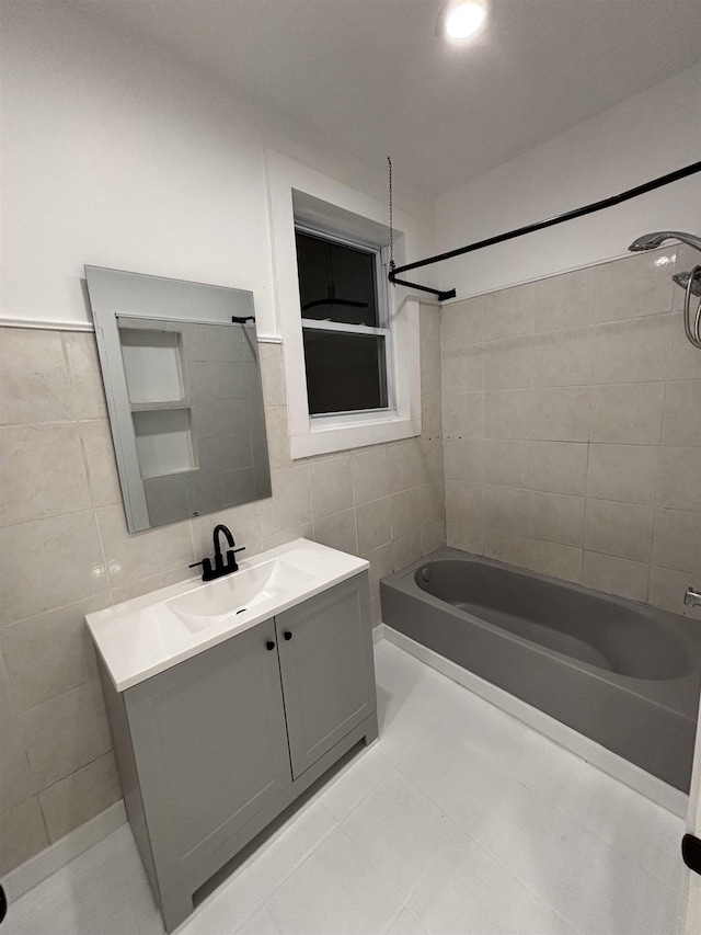 bathroom with shower / bathing tub combination, vanity, tile walls, and tile patterned floors