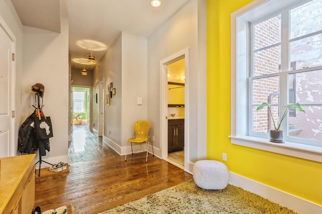 hall featuring baseboards, wood finished floors, and recessed lighting