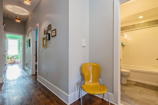 corridor featuring recessed lighting, wood finished floors, and baseboards