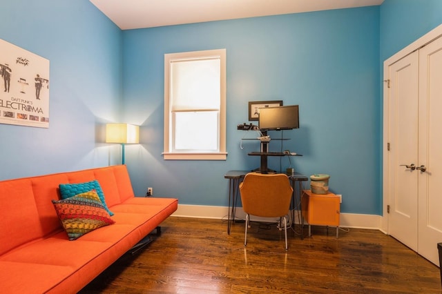 living area with baseboards and wood finished floors