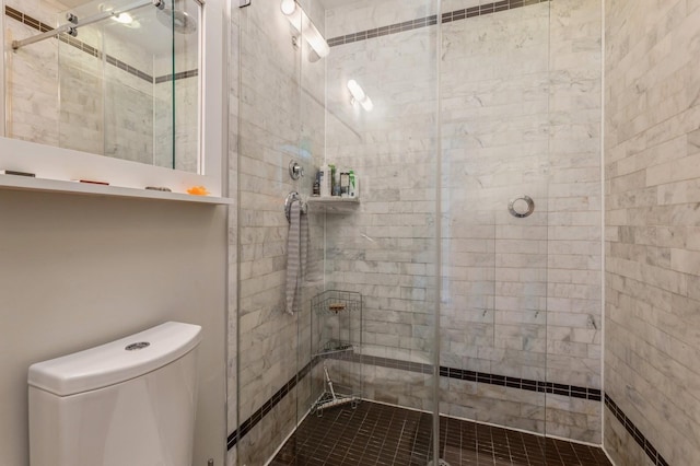 bathroom featuring a stall shower and toilet