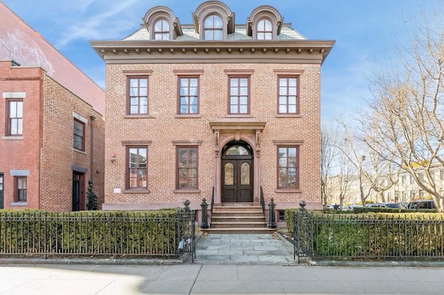 view of front of property featuring a fenced front yard, french doors, and brick siding