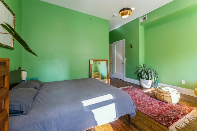 bedroom with visible vents, baseboards, and wood finished floors