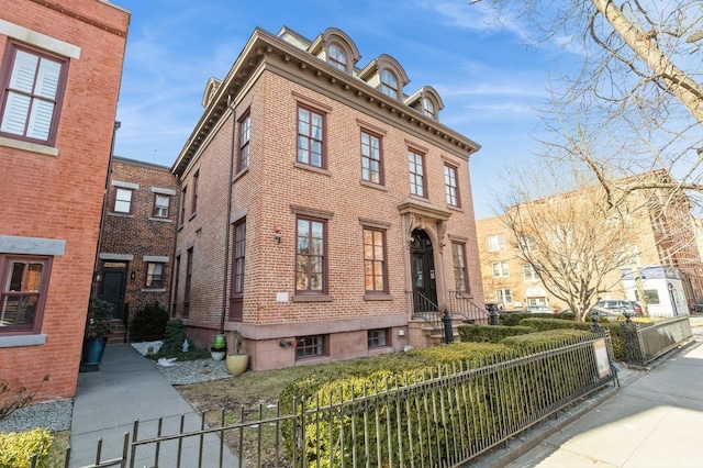 view of front of home with brick siding and a fenced front yard