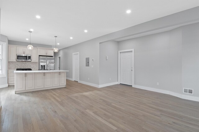 95 Claremont Ave, Jersey City, NJ 07304 - kitchen featuring stainless steel appliances, light wood finished floors, recessed lighting, a kitchen island with sink, and light countertops