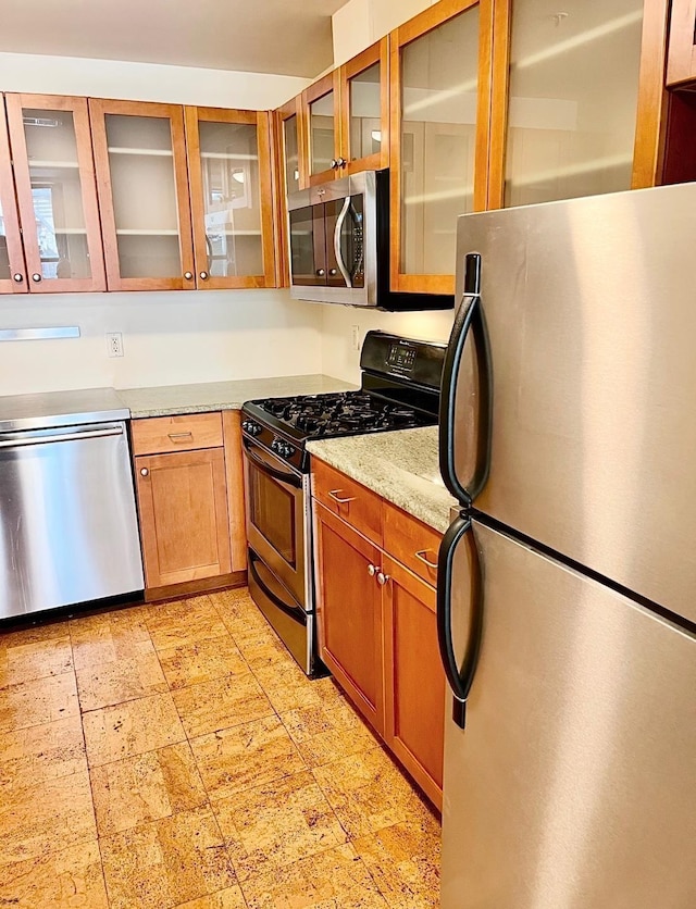 kitchen with light stone countertops and stainless steel appliances