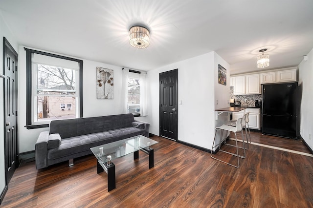 living room featuring baseboards and dark wood finished floors