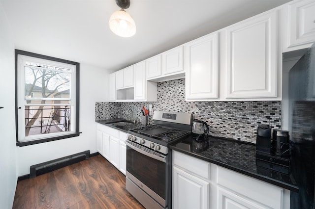 kitchen featuring tasteful backsplash, gas range, a sink, white cabinetry, and dark wood-type flooring
