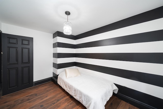 bedroom with baseboards and wood finished floors