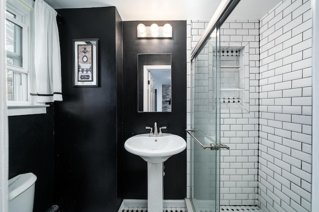 full bathroom with a shower stall, a sink, and toilet