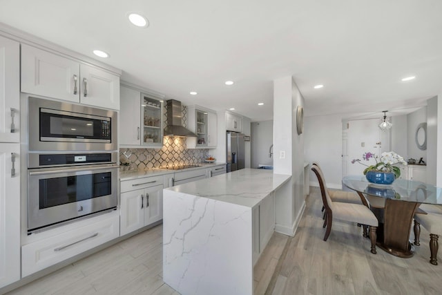 200 Winston Dr Unit 2502, Cliffside Park, NJ 07010 - kitchen featuring wall chimney range hood, stainless steel appliances, a peninsula, backsplash, and glass insert cabinets