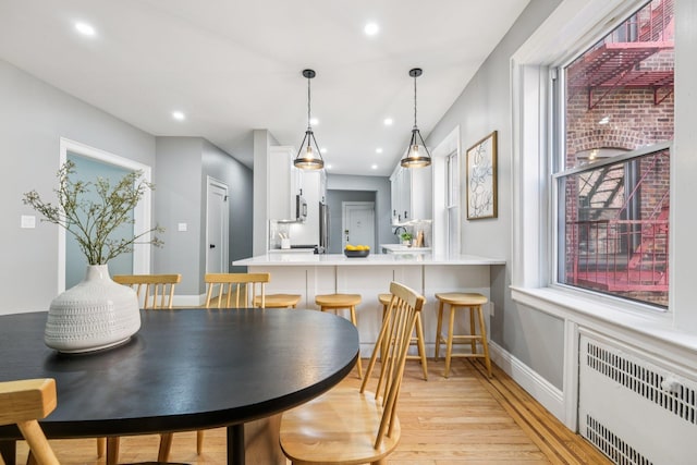 340 Fairmount Ave Apt 209, Jersey City, NJ 07306 - dining room with radiator heating unit, light wood-style floors, and recessed lighting