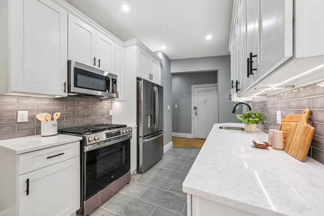 340 Fairmount Ave Apt 209, Jersey City, NJ 07306 - kitchen featuring appliances with stainless steel finishes, decorative backsplash, light stone counters, white cabinets, and recessed lighting