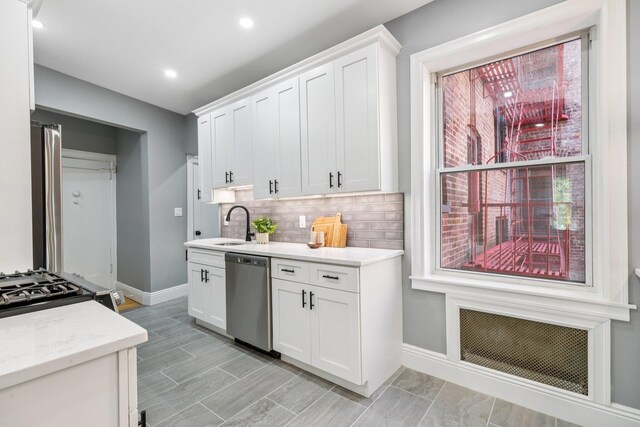 340 Fairmount Ave Apt 209, Jersey City, NJ 07306 - kitchen featuring stainless steel dishwasher, white cabinetry, tasteful backsplash, light stone counters, and recessed lighting