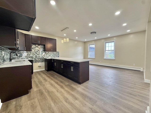 201 Livingston Ave, New Brunswick, NJ 08901 - kitchen with baseboard heating, a sink, light wood finished floors, a peninsula, and backsplash