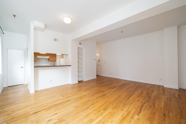 unfurnished living room with light wood-type flooring and built in features