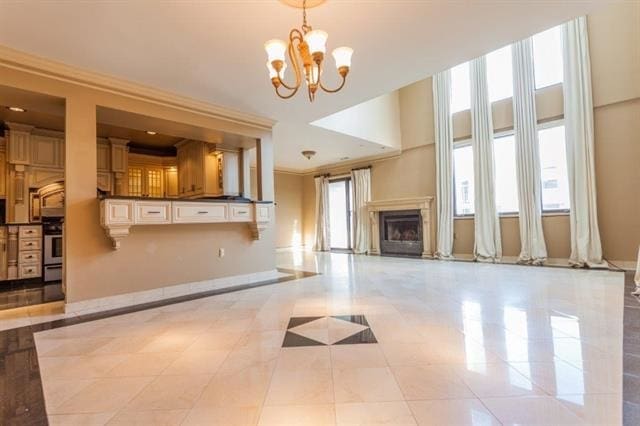 750 Mainsail Ln, Secaucus, NJ 07094 - unfurnished living room with light tile patterned floors, a fireplace, an inviting chandelier, and ornamental molding