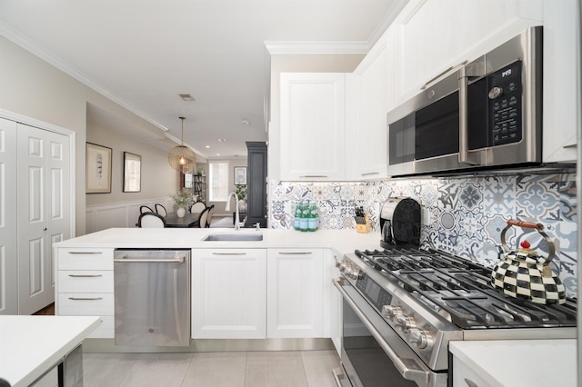 78 Madison St Unit 2, Hoboken, NJ 07030 - kitchen with stainless steel appliances, light countertops, a peninsula, backsplash, and crown molding