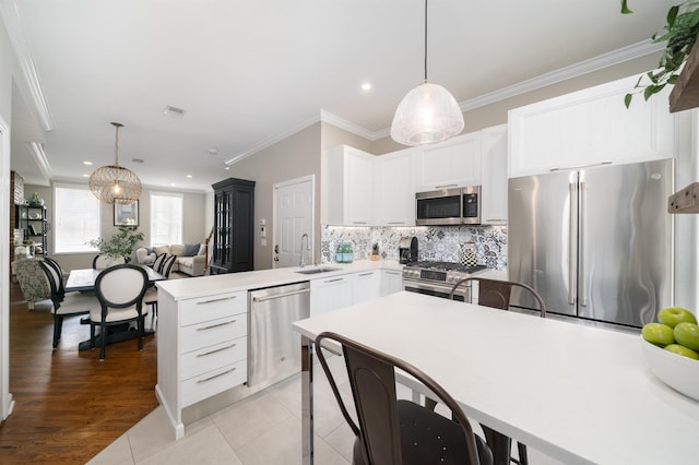 78 Madison St Unit 2, Hoboken, NJ 07030 - kitchen with stainless steel appliances, a peninsula, decorative backsplash, hanging light fixtures, and crown molding
