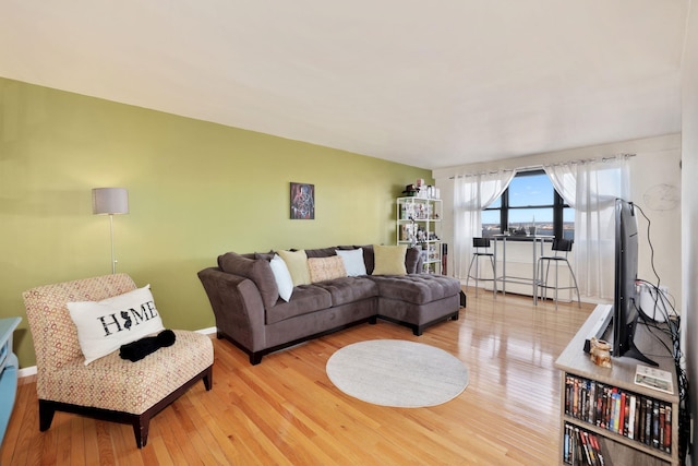 living room with light wood-type flooring and baseboard heating