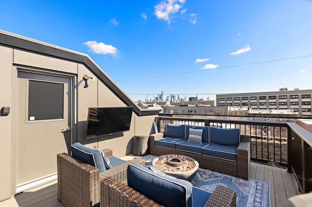 wooden deck featuring an outdoor living space with a fire pit