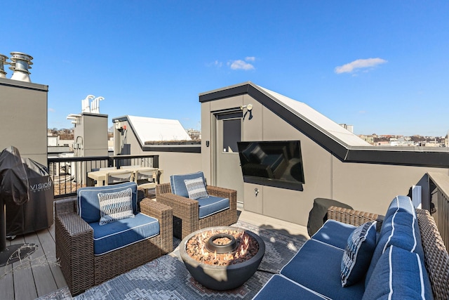 wooden deck featuring grilling area and an outdoor living space with a fire pit