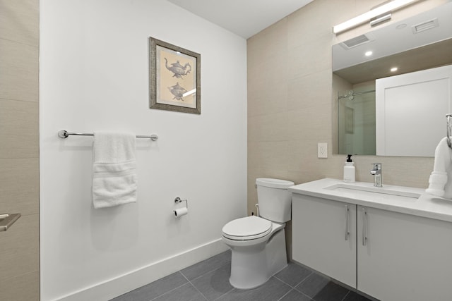 bathroom with vanity, tile patterned flooring, visible vents, toilet, and tile walls