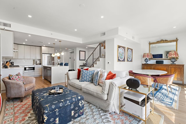 living room featuring recessed lighting, stairway, visible vents, and light wood-type flooring