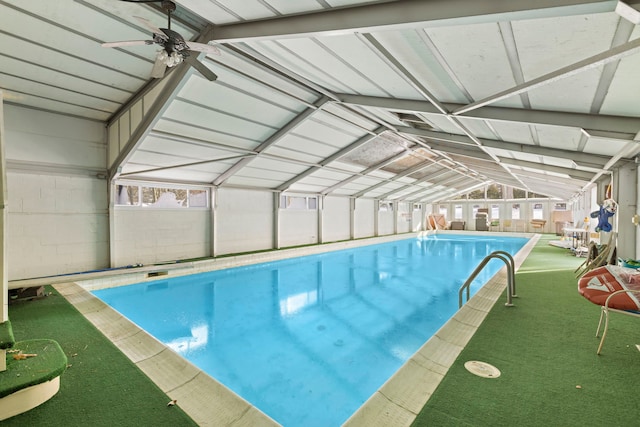 view of pool with glass enclosure and ceiling fan