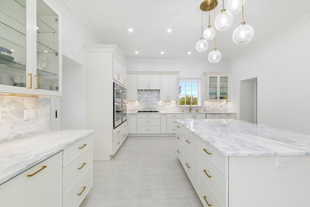 kitchen with white cabinets, a large island, light stone counters, and tasteful backsplash