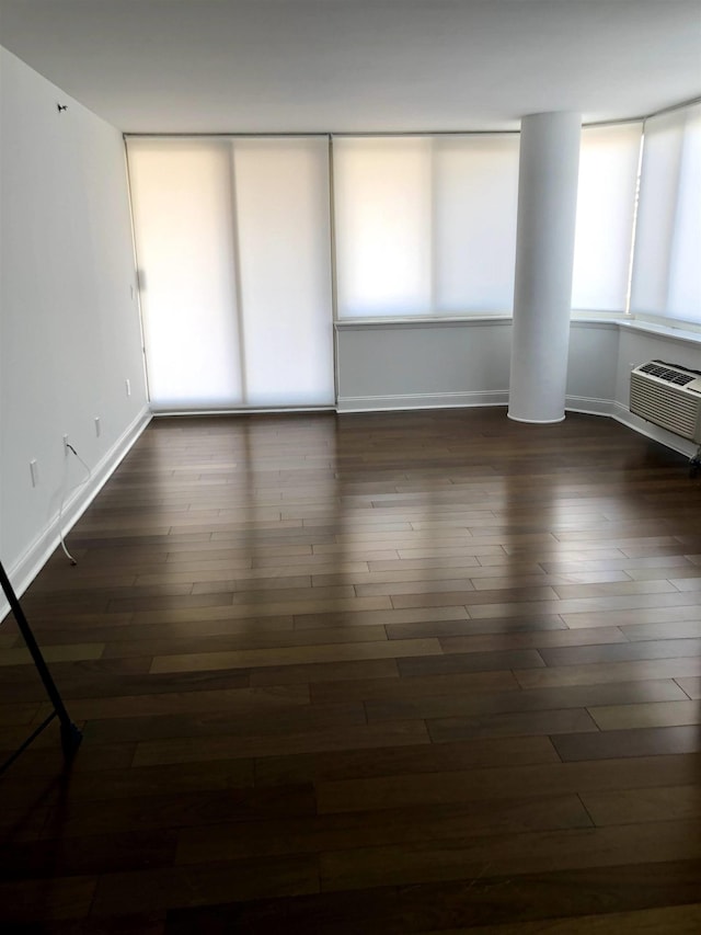 20 2nd St Unit 503, Jersey City, NJ 07302 - unfurnished room featuring dark wood-type flooring, a wall mounted AC, and plenty of natural light