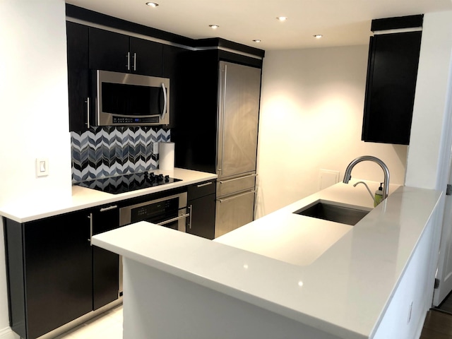 20 2nd St Unit 503, Jersey City, NJ 07302 - kitchen featuring appliances with stainless steel finishes, dark cabinetry, decorative backsplash, light countertops, and recessed lighting